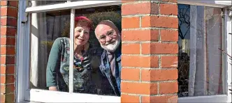  ?? AP Photo/ Elizabeth Dalziel ?? Bob and Sue Parsons look out from their window March 26 in Berkhamste­d, England. The Parsons have lived at the house for 40 years. They have seen changes on the street, but this is by far the strangest time they have lived through.