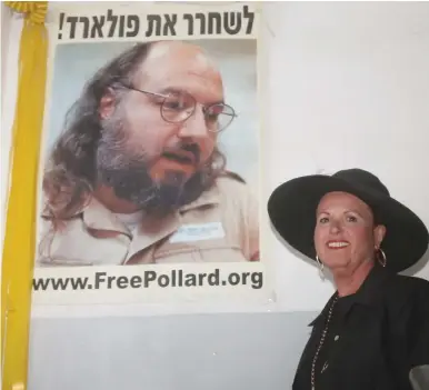  ?? (Marc Israel Sellem/The Jerusalem Post) ?? A DAY after his release was announced, Esther Pollard stands in front of a poster calling to free her jailed husband, Jonathan, which hangs in the staircase of their apartment building.