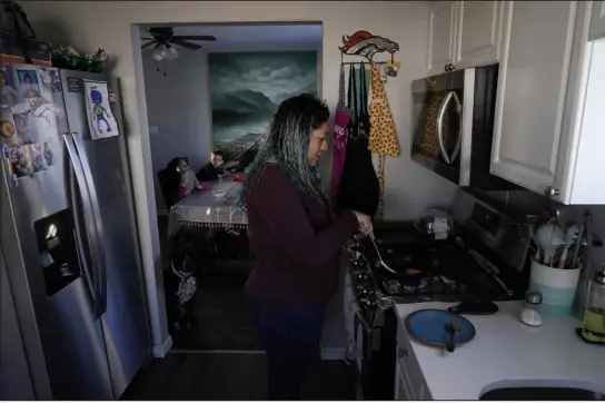  ?? BRITTANY PETERSON — THE ASSOCIATED PRESS ?? Betty Rivas prepares breakfast for her family Feb. 23 in Commerce City. Rivas was startled by a letter telling her the drinking fountains her 8-year-old used at school weren’t safe. PFAS stories had been in the news, and the school district told families to use bottled water.