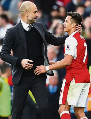 ??  ?? You’ll make a good Citizen: Manchester City manager Pep Guardiola greeting Arsenal’s Alexis Sanchez after the English Premier League match on April 3. — Reuters