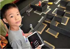  ??  ?? Joshua Chen plays in the Star Wars Spheros robotics zone at Star Wars Day.