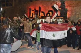  ?? SANA ?? Syrians celebrate as they hold their national flags in Aleppo province, Syria, on Monday.