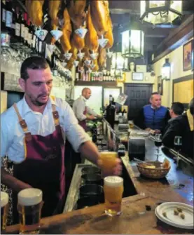  ?? / PACO PUENTES ?? Un camarero sirve cerveza en un bar de Sevilla.