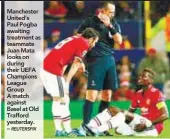  ?? REUTERSPIX ?? Manchester United’s Paul Pogba awaiting treatment as teammate Juan Mata looks on during their UEFA Champions League Group A match against Basel at Old Trafford yesterday. –