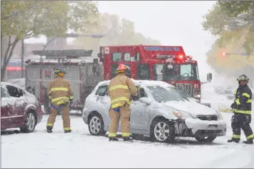  ?? Herald photo by Tijana Martin ?? Members of the Lethbridge Fire Department help clear up a minor two-vehicle collision downtown along 8 Street South on Monday afternoon. It was a busy day for Lethbridge first responders and Coaldale RCMP as parts of southern Alberta dealt with the...