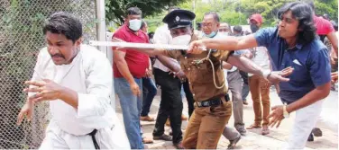  ?? Agence France-presse ?? ↑ Demonstrat­ors and government supporters clash outside the president’s office in Colombo on Monday.