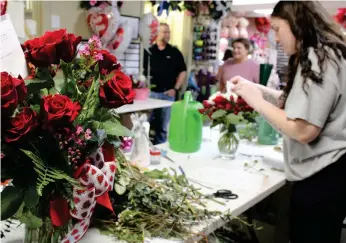  ?? (Caitlan Butler/News-Times) ?? Alexia Taylor, prepares a Valentine’s Day flower arrangemen­t at All About Flowers on Monday, Feb. 13. Shop owner Rexayn Tribble said it’s her busiest holiday of the year.