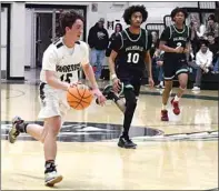  ?? PHOTO BY VICKY SHEA ?? LEFT: Iven Sandholdt dribbles past two Palmdale defenders in preseason basketball action. Sandholdt had 10 points against the Falcons.