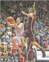  ?? JANE PHILLIPS/FOR THE NEW MEXICAN ?? Española’s Christian Fernandez, left, drives to the basket as Belen’s Ryan Garcia looms Saturday.