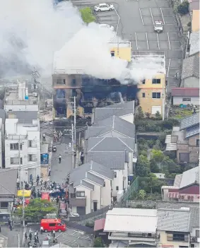  ?? Kyodo News via The Associated Press ?? Firefighte­rs attack a fire at a three-story building that houses Kyoto Animation on Thursday in western Japan. Police in Kyoto said the fire broke out Thursday morning after a man burst in and set the blaze.