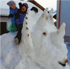  ??  ?? Simon und Lea aus Pfronten haben mit ihrer Mama einen Schneesaur­ier im Garten gebaut.