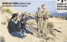  ??  ?? SPREAD THIN Soldiers talk to migrant men in Cyprus