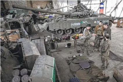  ?? FINBARR O'REILLY NYT ?? Mechanics at a garage in the eastern Ukrainian city of Kharkiv repair military vehicles, including captured Russian tanks.