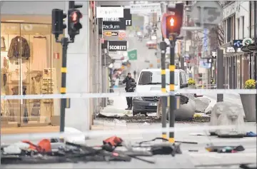  ??  ?? A turned over ‘Stockholms­lejon’, a concrete traffic stopper, is seen outside the roped off area next to the department store Ahlens after a suspected terror attack on the Drottningg­atan Street in central Stockholm. — Reuters photo