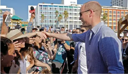  ??  ?? BRITAIN’S PRINCE WILLIAM visits a Tel Aviv beach yesterday.