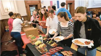  ?? BILL UHRICH/READING EAGLE ?? German exchange students from Reutlingen line up for lunch during a visit to Reading City Hall on Friday.