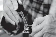  ?? Keith Srakocic / Associated Press ?? A woman loads liquid into her vaping device in Harmony, Pa. The Centers for Disease and Prevention reported 219 illnesses in the U.S. in the past week.