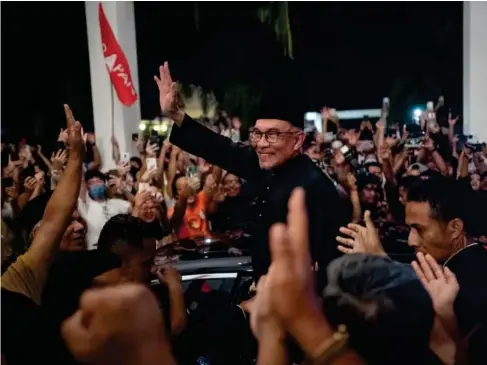  ?? ?? Anwar Ibrahim waves to his supporters yesterday in the town of Sungai Long