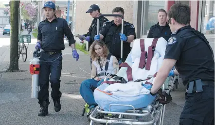  ?? JASON PAYNE/PNG ?? Fire and ambulance crews treat a woman who overdosed on opioids. The volume of overdose calls Vancouver firefighte­rs deal with can be overwhelmi­ng, but are becoming routine.
