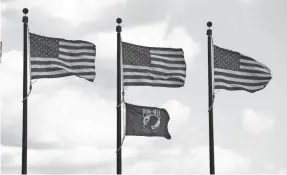  ?? SAM UPSHAW JR./COURIER JOURNAL ?? A brisk wind blew the flags during the Tri An Monument dedication ceremony at the Veterans Memorial Park in Jeffersont­own on Oct. 9. The monument was erected to honor Vietnam War veterans.