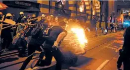  ?? BILLY H.C. KWOK/GETTY ?? Protesters push a burning cart toward police during a demonstrat­ion in Hong Kong.