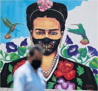  ?? PHOTO: REUTERS ?? Silent message . . . A man walks past a mural of painter Frida Kahlo, depicted in a protective mask, in Mexico City. Mexico yesterday reported just over 7000 new Covid19 cases and 856 deaths in the past 24 hours. The country has about 311,000 cases in total.