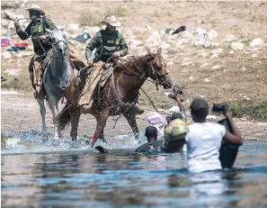  ?? (AP Photo/Felix Marquez) ?? U.S. Customs and Border Protection mounted officers attempt to contain migrants as they cross the Rio Grande from Ciudad Acuña, Mexico, into Del Rio, Texas, Sunday, Sept. 19, 2021. Thousands of Haitian migrants have been arriving to Del Rio, Texas, as authoritie­s attempt to close the border to stop the flow of migrants.