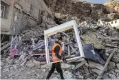  ?? AP ?? A volunteer helps salvage items from homes which were damaged by the earthquake in the town of Imi N’tala, outside Marrakech, Morocco, Wednesday.