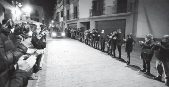  ??  ?? Centenares de vecinos arroparon a la familia de David Beriain en la llegada del coche fúnebre al pueblo.