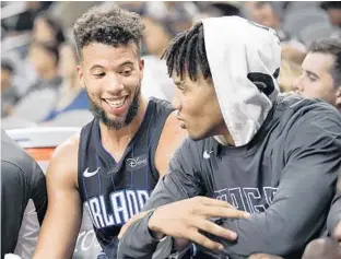  ?? DARREN ABATE/AP ?? The Magic’s Michael Carter-Williams, left, and Markelle Fultz talk during a recent preseason game. Fultz, a point guard, enjoys the team’s camaraderi­e: “Everybody loves coming to work every day,” he said.