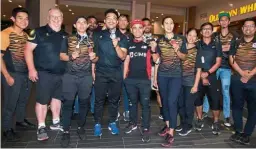  ?? — GLENN GUAN/The Star ?? In high spirits: Cyclist Azizulhasn­i Awang (wearing CIMB T-shirt) posing with the Asian Cycling Track Championsh­ips sprint gold medal at the Kuala Lumpur Internatio­nal Airport 2 on Tuesday.