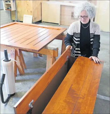  ?? [PHIL MASTURZO/AKRON BEACON JOURNAL] ?? Secret Compartmen­ts Furniture owner Jill Herro tests the hiding place in a piece of furniture at a Amish facility in Fredericks­burg that builds according to her designs.