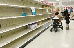  ?? JIM WATSON/GETTY-AFP ?? A woman shops for baby formula last month in Annapolis, Maryland. Storms this week forced a Michigan plant to pause production amid a national shortage.