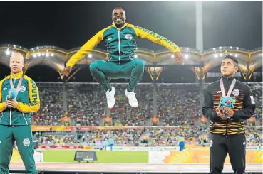  ?? /Roger Sedres/Gallo Images ?? Inspired: Gold medal winner in the T12 100m, Jonathan Ntutu, centre, Hilton Langenhove­n (silver), left, and Mohamad Ali Hanafiah Muhammad Afiq (bronze) of Malaysia show off their medals on the podium.