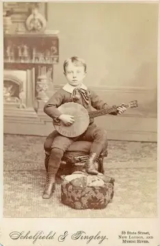  ?? MYSTIC SEAPORT MUSEUM ?? Scholfield &amp; Tingley were typical of 19th-century photograph­ers in using artistic elements to compose their portraits, in this case the backdrop, chair, footstool and banjo. The photo is from circa 1888.