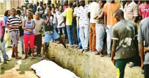  ??  ?? People gather around the body of a man shot dead in the Nyakabiga neighbourh­ood of Bujumbura