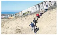  ?? PHOTO: REUTERS ?? Desperate to get in . . . Migrants from Honduras, walk next to the USMexico border fence as they prepare to cross it illegally, in Tijuana, Mexico.