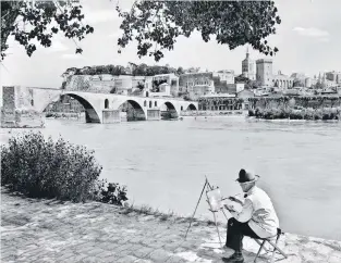  ??  ?? PROVENCE GLORY is available through Assouline.com.
Painter in front of the Saint-Bénézet bridge, also known as
the Pont d’Avignon. Roger Viollet