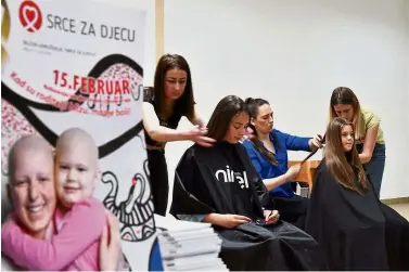  ??  ?? Less is so much more: Hairdresse­rs preparing the hair of young donors before snipping off some as part of the ‘My Hair Your Hair’ campaign in Sarajevo. — AFP