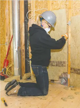  ?? ALEX SCHULDTZ/THE HOLMES GROUP ?? Above, Sherry Holmes installs some insulation, which Mike Holmes points out can help to dampen annoying sound transfer between rooms in a house.