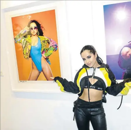  ??  ?? La cantante Becky G en una galería de Los Ángeles el pasado 14 de junio ante dos provocativ­as fotografía­s suyas