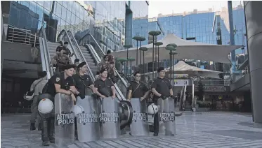  ?? NikolŻs Georgiou/ picture©esk.com ?? Polizisten sichern den Eingang von Mega TV in Athen.