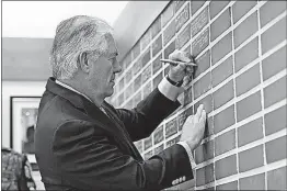  ?? [LEE JIN-MAN, POOL PHOTO] ?? In Paju, South Korea, Secretary of State Rex Tillerson writes a message for soldiers on a brick wall Friday at Camp Bonifas, near the border village of Panmunjom, which has separated the two Koreas since the Korean War. Tillerson greeted U.S. soldiers...