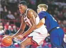  ?? AUSTIN ANTHONY DAILY NEWS VIA AP ?? Western Kentucky center Charles Bassey, left, drives while guarded by Kentucky Wesleyan forward Amandas Urkis during WKU’s 96-71 win in an exhibition game Saturday in Bowling Green, Ky.