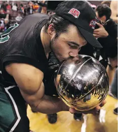  ?? JOHN MAJOR ?? Michael Linklater kisses the trophy after helping the University of Saskatchew­an Huskies win the 2010 Canadian men’s university basketball championsh­ip. Linklater is now with the Coaches Associatio­n of Saskatchew­an while also serving as a motivation­al...