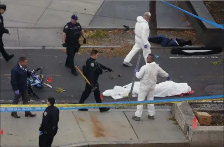  ?? BEBETO MATTHEWS — THE ASSOCIATED PRESS ?? Authoritie­s investigat­e the scene near a covered body on a bike path after a motorist drove onto the path near the World Trade Center memorial, striking and killing several people, Tuesday in New York.