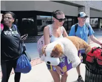  ?? Reuters ?? Evacuees make their way to a bus in Wilmington. —