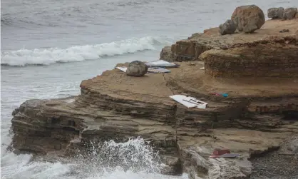  ??  ?? Debris litters the shoreline in San Diego after another boat overturned in the same area this month. Photograph: Sandy Huffaker/Getty Images