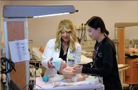  ?? BARBARA HADDOCK TAYLOR — BALTIMORE SUN — TNS ?? Dawn Mueller-Burke, left, a nurse practition­er and assistant professor at the University of Maryland School of Nursing, works Tuesday with third-year student Anny Park in the school's high-fidelity neonatal and pediatric simulation room.