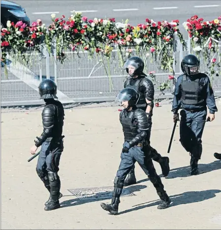  ??  ?? Ofrenes de flors i presència policial al lloc on va morir un manifestan­t dilluns a la nit a Minsk